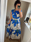 Women’s blue floral maxi dress with oversized flower print and polka dots on ivory background, relaxed fit with gathered neckline, styled with gold belt
